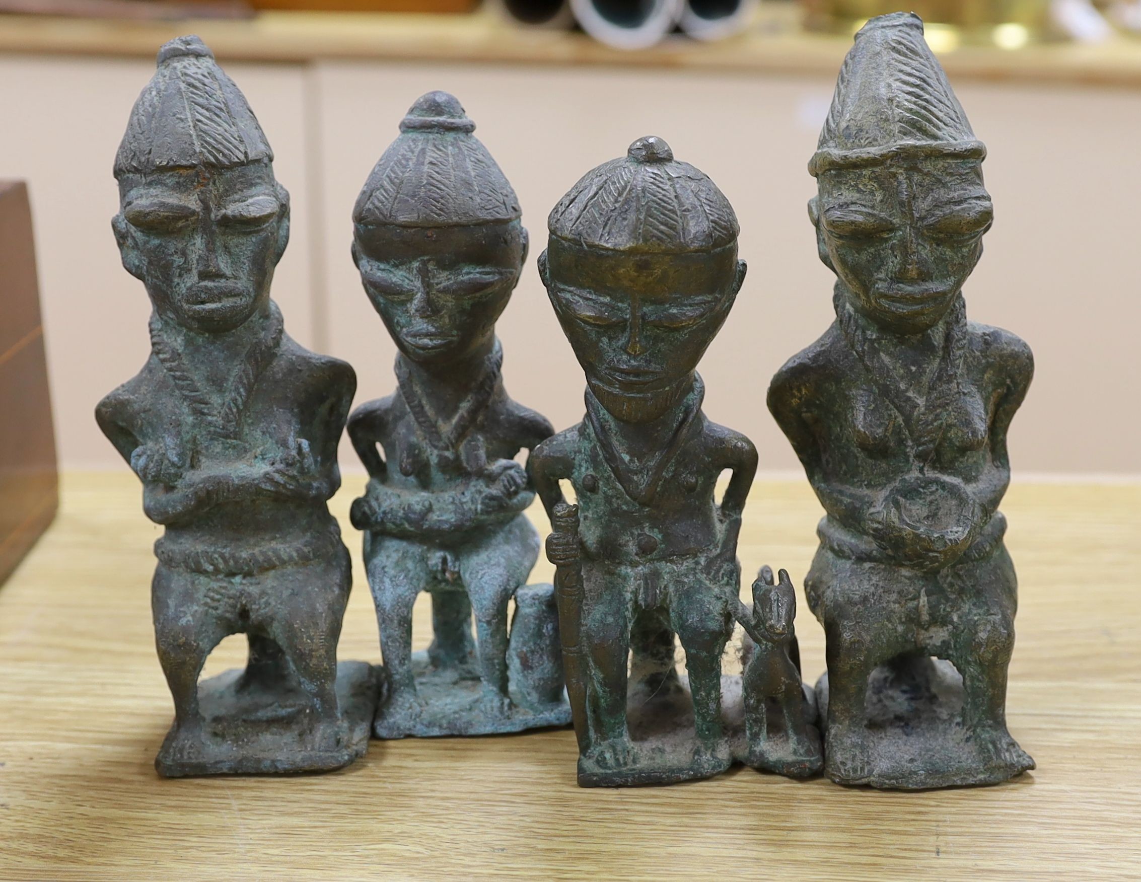 A group of Nigerian cast metal figures, bangles and a dish, tallest 36 cms high.